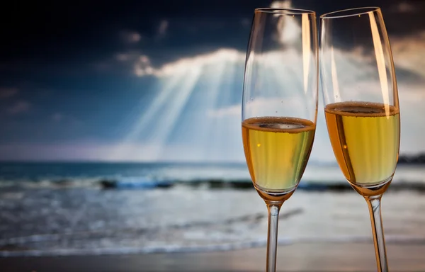 Champagne glasses on tropical beach at sunset - exotic New Year — Stock Photo, Image