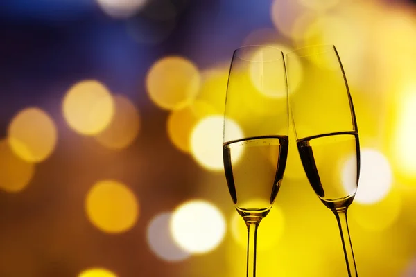 Toasting with champagne glasses against holiday lights — Stock Photo, Image