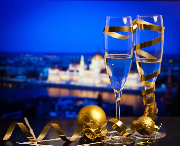 Új év, a város - pezsgős pohár és a város fényei a háttérben — Stock Fotó