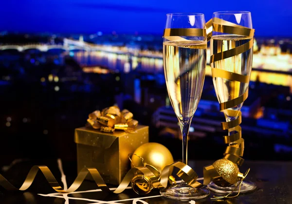 Nuevo año en la ciudad - copas de champán y luces de la ciudad en el fondo — Foto de Stock