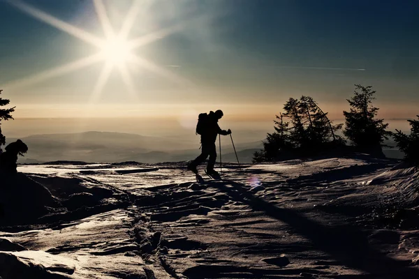 Narciarz backcountry, osiągając szczyt w zachód słońca — Zdjęcie stockowe