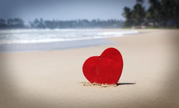 Corazón rojo en la playa de arena exótica - Concepto de San Valentín — Foto de Stock