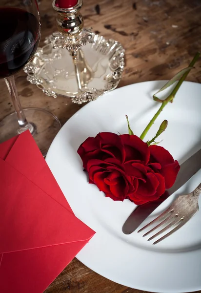 Tischdekoration mit roten Rosen auf Teller - zum Valentinstag — Stockfoto