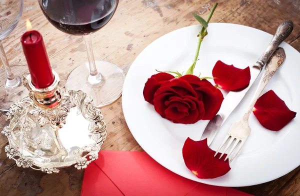 Tischdekoration mit roten Rosen auf Teller - zum Valentinstag — Stockfoto