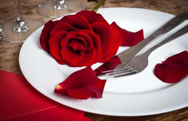 Накрытие стола с красными розами на тарелке - празднование Дня Святого Валентина — стоковое фото