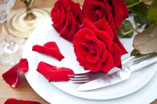 Cenário de mesa com rosas vermelhas no prato - celebrando o Dia dos Namorados — Fotografia de Stock