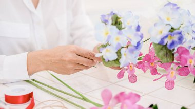 Çiçekçi dükkanında çiçek kompozisyon hazırlayan kadın elleri. Kendin yap konsept..