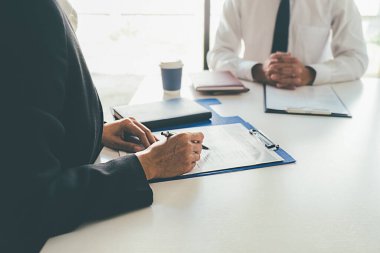 Bir şirket personel müdürüyle iş görüşmesi yapan çekici genç bir iş kadını.