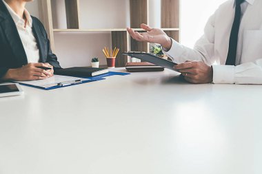 Bir şirket personel müdürüyle iş görüşmesi yapan çekici genç bir iş kadını.