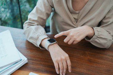 Masasında dizüstü bilgisayar ve kağıtlarla oturan genç ve güzel iş kadını ofiste ya da iş yerinde mutlu, sevinçli ve başarılı, tamamlanmış işi kutluyor. İş, başarı kavramı.