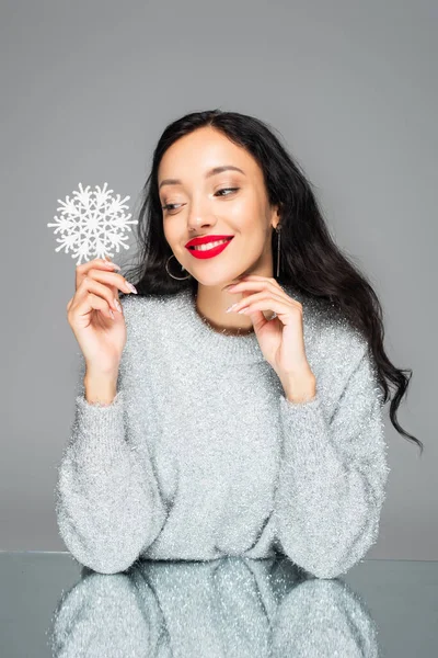 灰色で隔絶された装飾的な雪の結晶を保持赤い唇を持つ幸せな女性 — ストック写真
