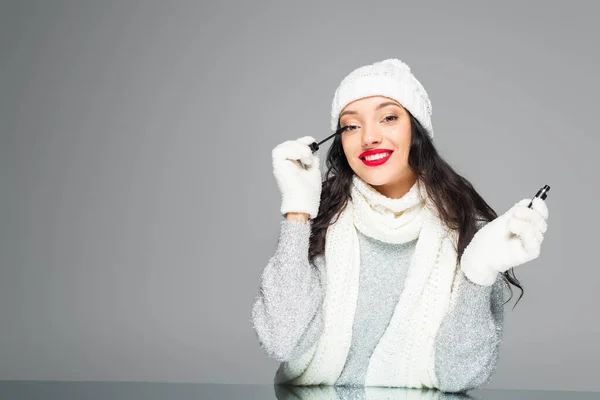 Gelukkig Brunette Vrouw Winter Outfit Van Toepassing Mascara Geïsoleerd Grijs — Stockfoto
