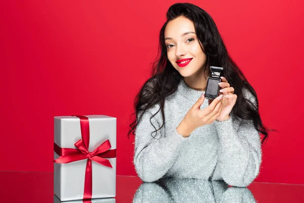 Jovem Mulher Satisfeita Camisola Segurando Garrafa Com Perfume Perto Embrulhado — Fotografia de Stock