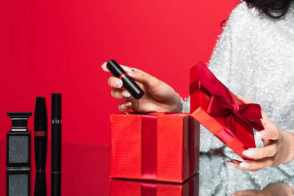 女性从礼品盒上摘下口红的剪影 接近红色装饰化妆品 — 图库照片