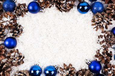 Beyaz desenli arka planda, çam kozalakları ve noel mücevherleriyle yatıyordu.