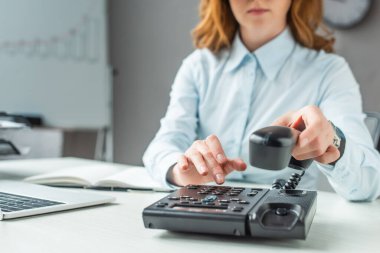 İş yerindeki sabit telefondan cep telefonu numarasıyla iş kadını görüntüsü bulanık.
