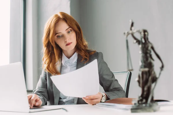 Redhead Lawyer Looking Paper Sheet While Sitting Laptop Table Blurred — Stock Photo, Image