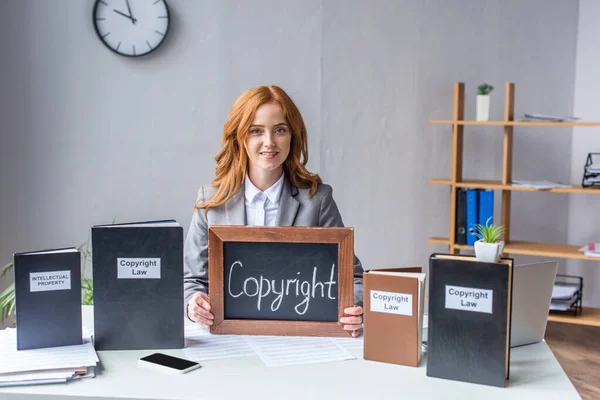 Avvocato Sorridente Che Mostra Lavagna Con Scritte Copyright Vicino Libri — Foto Stock