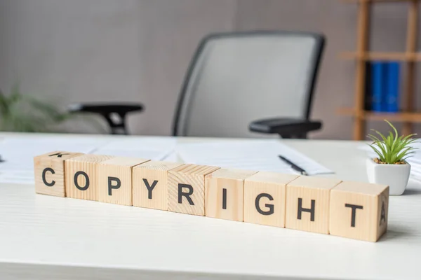 Close Van Houten Kubussen Met Copyright Belettering Met Wazig Werkplek — Stockfoto