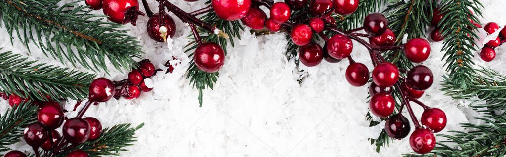 top view of spruce branches and artificial red berries on white textured background, banner