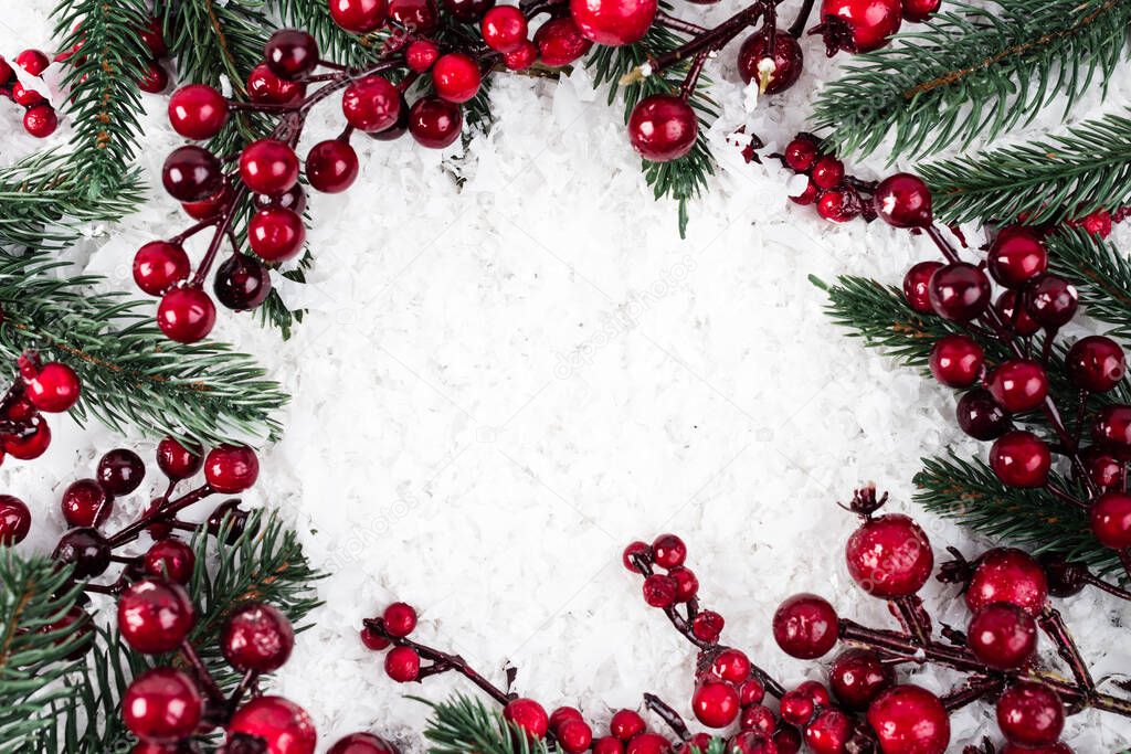 Top view of pine branches and artificial berries on white textured background