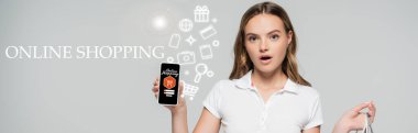 Çevrimiçi alışveriş mektuplarının yanında akıllı telefonu tutan şok olmuş bir kadın.