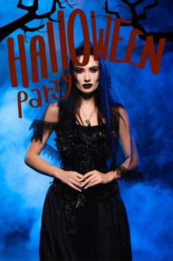 Siyah elbiseli gelin ve dumanlı cadılar bayramı partisinin yanında dumanlı mavi harflerle.