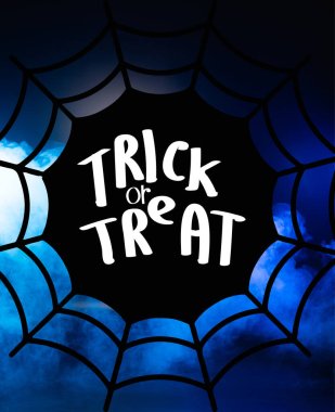 trick or treat lettering and spider web illustration on dark blue background  clipart