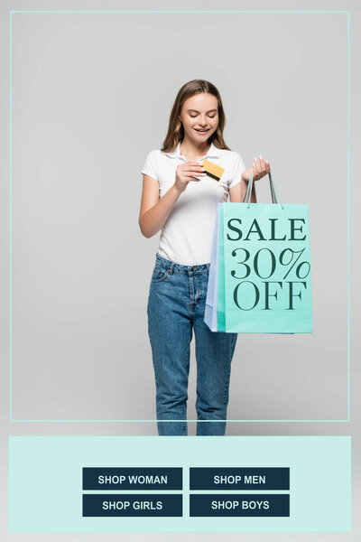 радостная женщина с кредитной картой и глядя на синие сумки для покупок с продажей 30 процентов со скидкой надписи на сером