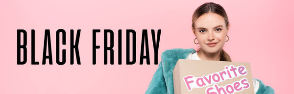 stylish woman in sunglasses holding box with favorite shoes near black friday lettering on pink, banner