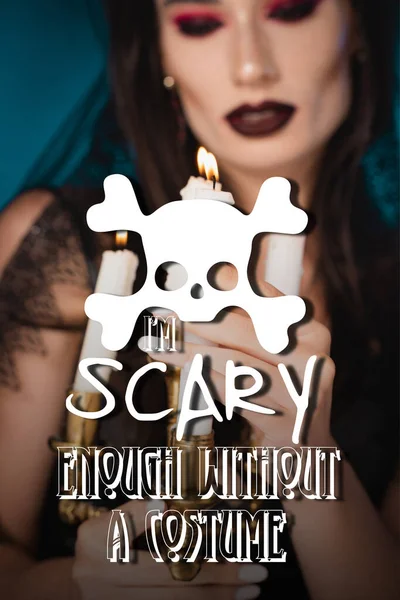 pale woman with makeup touching burning candles near i am scary enough without costume lettering on blue