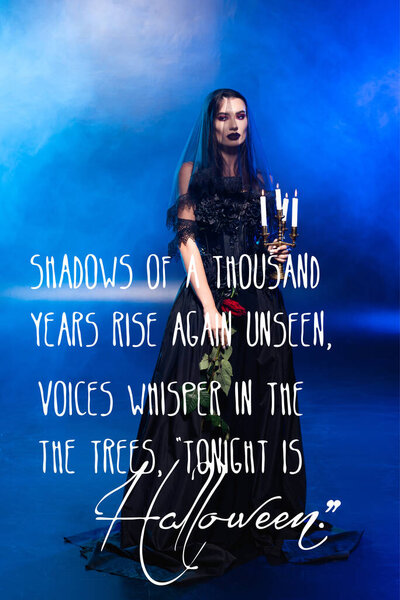 bride in black dress and veil holding rose and candles near poem on blue with smoke