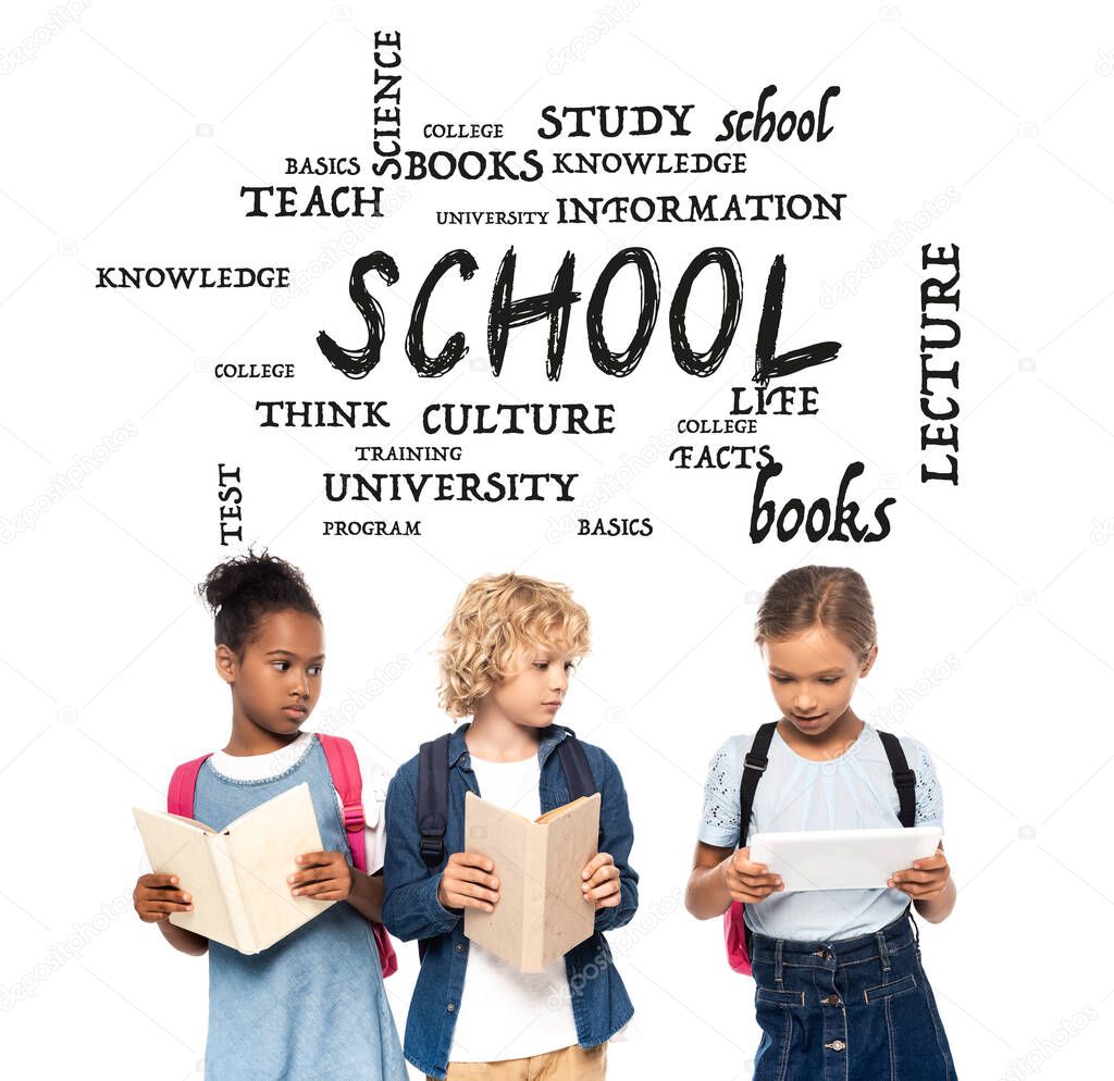 african american schoolgirl and blonde schoolboy with books looking at digital tablet in hands of classmate near lettering on white 