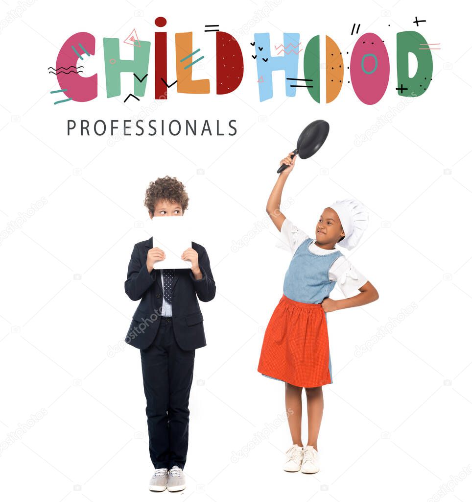 african american kid pretending housewife and holding frying pan near boy in suit and childhood professionals lettering on white 