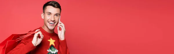 Young Man Christmas Sweater Smiling While Talking Smartphone Holding Shopping — Stock Photo, Image