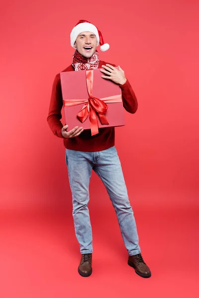 Positive Man Santa Hat Scarf Holding Gift Box Ribbon Red — Stock Photo, Image