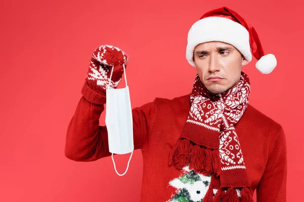 Sad Man Santa Hat Holding Medical Mask Isolated Red — Stock Photo, Image