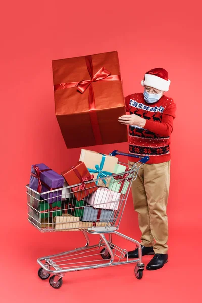 Senior Man Medical Mask Santa Hat Holding Present Shopping Cart — Stock Photo, Image