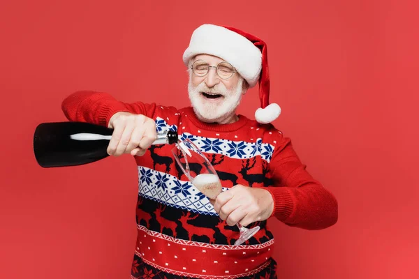 Smiling Senior Man Santa Hat Pouring Champagne Glass Isolated Red — Stock Photo, Image