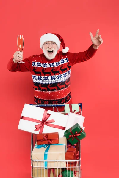 Homem Animado Santa Chapéu Segurando Copo Champanhe Perto Carrinho Compras — Fotografia de Stock