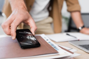 Bulanık arka plandaki kağıt yığınından aldığı kokainle akıllı telefonu alan işadamı görüntüsü