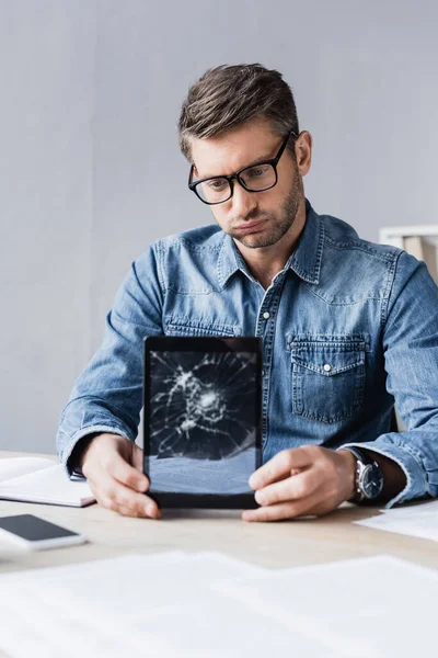 Unavený Podnikatel Rozbitým Digitálním Tabletem Sedící Pracovišti Rozmazaném Popředí — Stock fotografie