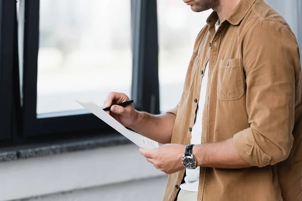 Cropped View Businessman Standing Writing Document Blurred Window Background — Stock Photo, Image