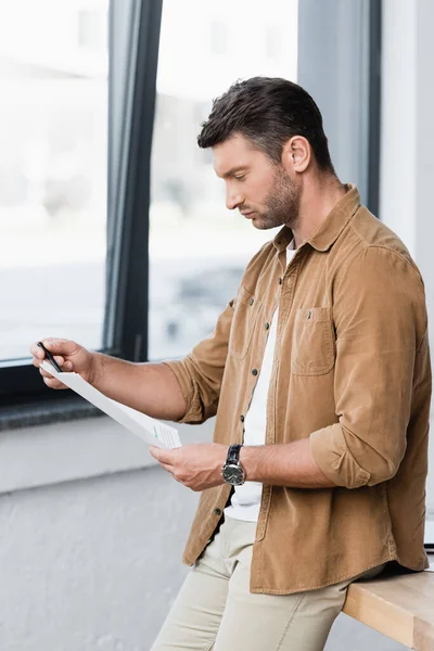 Focused Businessman Looking Document While Leaning Table Blurred Background — Stock Photo, Image