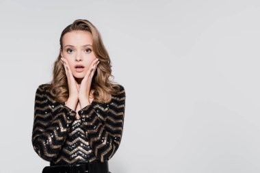 Gri renkli kameraya bakan şok olmuş genç bir kadın. 