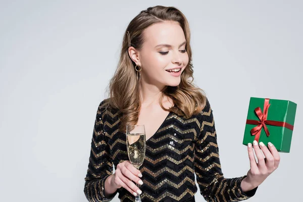 Gelukkig Vrouw Met Glas Champagne Verpakt Kerstcadeau Geïsoleerd Grijs — Stockfoto
