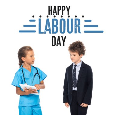 child in costume of doctor holding digital tablet near curly boy in formal wear and happy labour day lettering on white  clipart