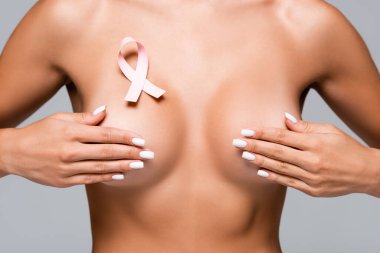 Göğüs kanseri kurdeleli çıplak kadın görüntüsü. Gri göğüslere dokunuyor. 