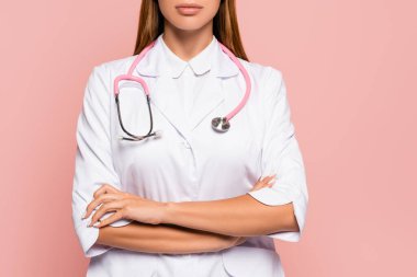 Steteskoplu ve kollarını çapraz bağlamış pembe renkli doktor görüşü.