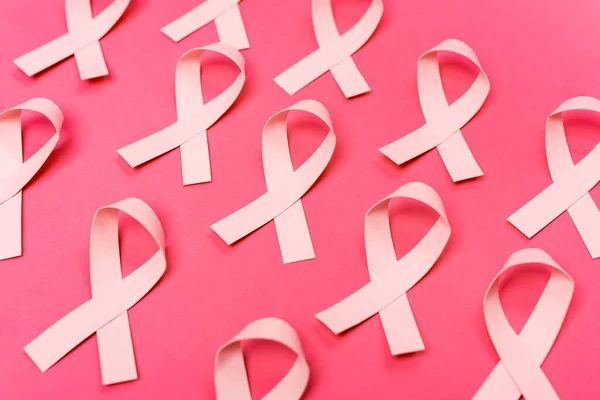 ピンクの背景に乳がんの認識のリボンの行 — ストック写真